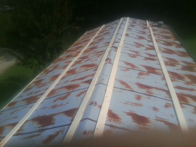 Rusted metal roof panels with new wood purlins before replacement — Storm Damage Roof Repair in Caney by Roofing Brothers